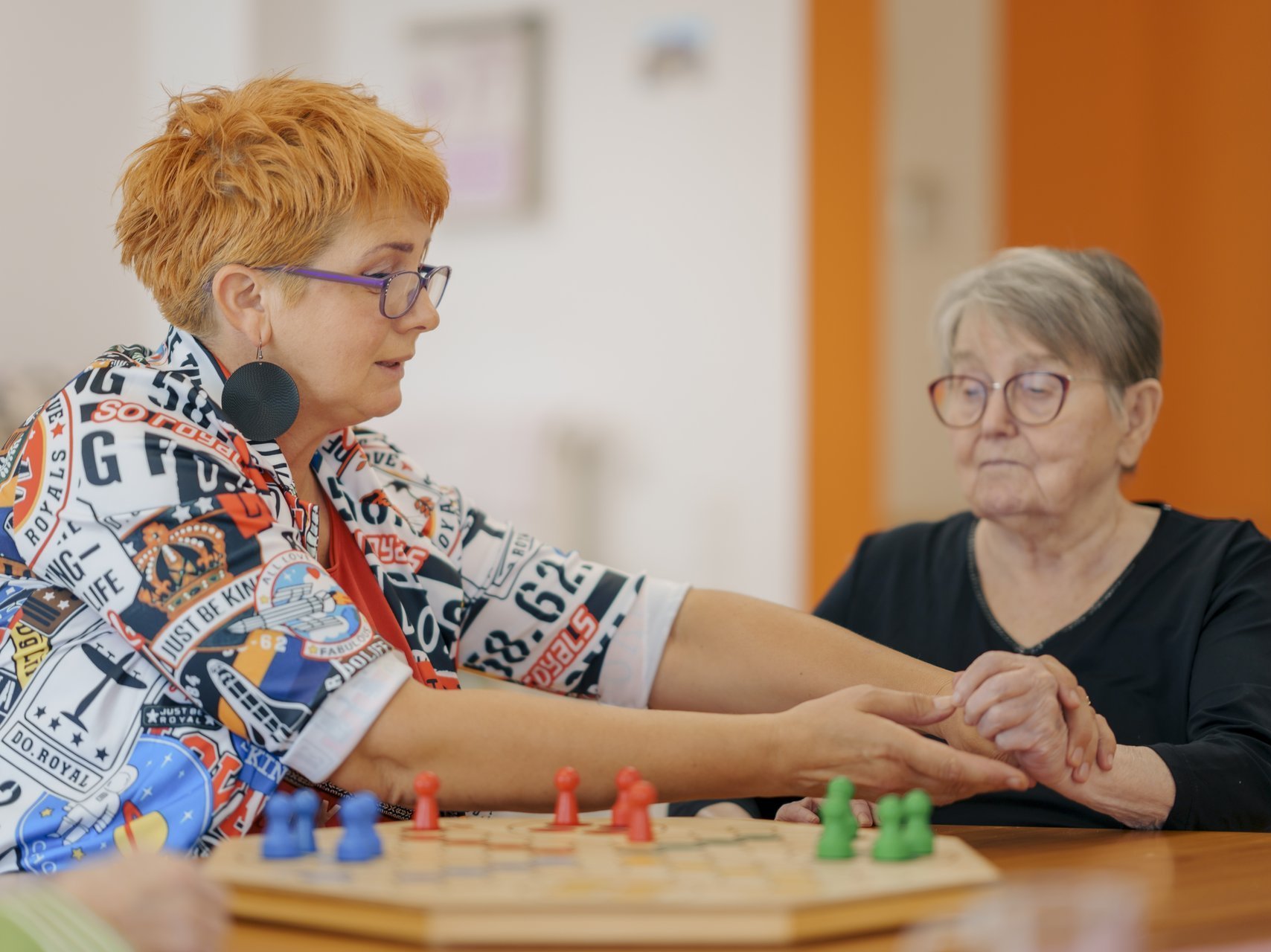 Zwei Damen mit Brille spielen zusammen ein Brettspiel