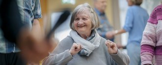 Matthias Pullem Haus eine Frau im Rollstuhl sieht glücklich in die Kamera und hat Spass